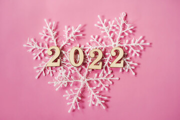 Pink pastel flatlay with snowflakes and wooden eco-friendly Christmas and New Year 2022 decorations