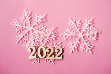 Pink pastel flatlay with snowflakes and wooden eco-friendly Christmas and New Year 2022 decorations