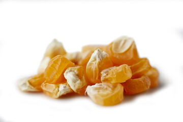 A small pile of corn seeds on a white background isolated health concept