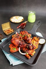 Tandoori chicken is a popular roast chicken recipe from India.   Tandoor is a traditional wood oven. Chicken Tandoori Platter is served in a brass plate with salad and spices. Copy Space. 