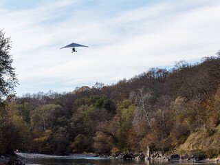 Flying a motorized hang glider on an autumn sunny day.