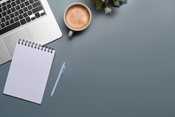 Top view laptop computer, empty notebook and cup of coffee on blue background.