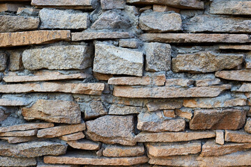 Natural stone masonry wall or fence concept background texture