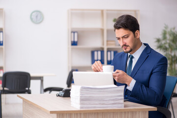Fototapeta premium Young male employee drinking coffee during break