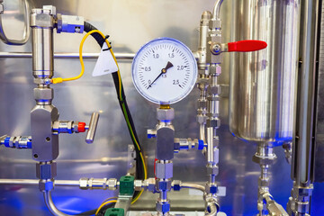 Pressure brush on production equipment. Chromed production equipment. Red valves on chrome pipes....