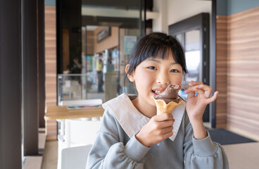 ソフトクリームを食べる小学生の女の子