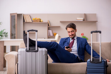 Young businessman preparing for trip at home
