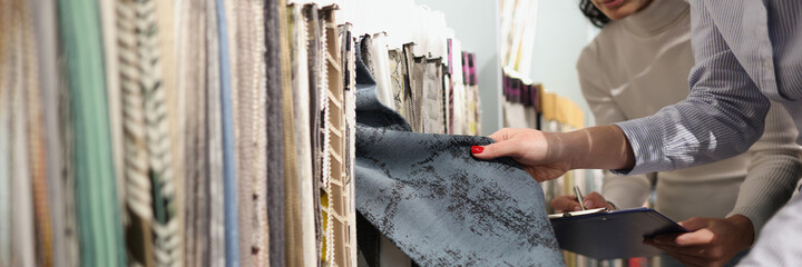 Seller and buyer choose fabrics for curtains in showroom