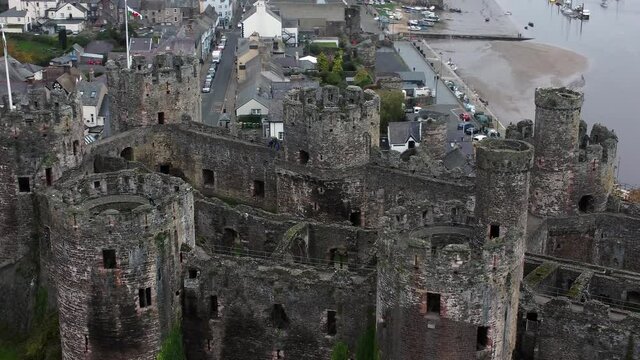 Historic Conwy castle aerial view of Landmark town ruin stone wall battlements tourist attraction close orbit right
