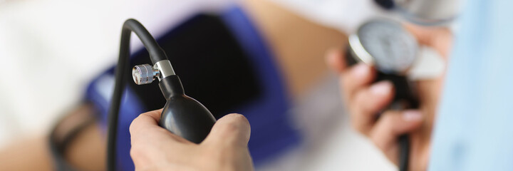 Doctor using tonometer checking blood pressure to patient in hospital