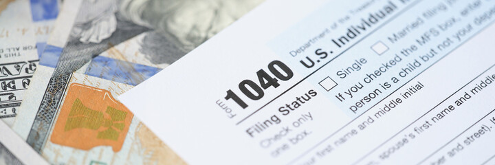 Individuals tax return form 1040 and dollars are on table