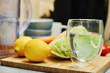 Glass of pure water, fcleaning filter cartridge and fresh vegetables on table