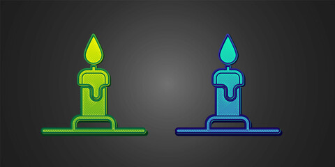Green and blue Burning candle in candlestick icon isolated on black background. Cylindrical candle stick with burning flame. Vector