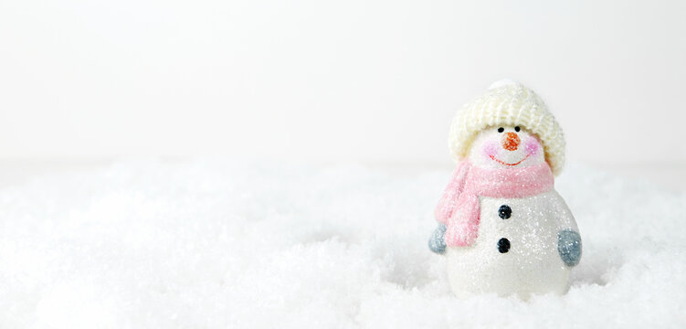 Christmas background. Happy snowman standing in winter snowy Christmas landscape. Merry christmas and happy new year greeting card. Funny snowman in a hat on a snowy background. Banner.