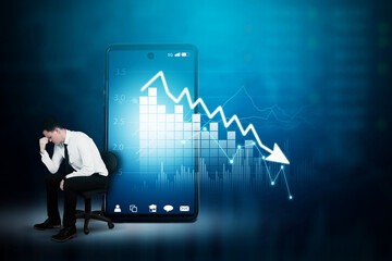 Stressed businessman sitting with declining chart