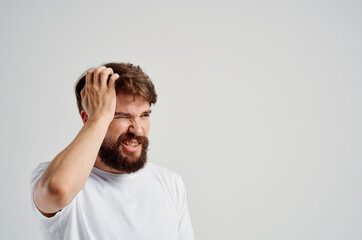 bearded man holding his head pain stress emotions isolated background