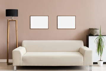 Two blank picture frame mockup on wall. Modern living room design. View of scandinavian style interior with sofa. Home staging and minimalism concept