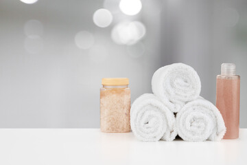 Obraz na płótnie Canvas Spa still life with towels and skincare cosmetics against blurred background