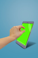 Modern digital smartphone on stand and female hand maximizing green chromakey screen