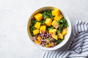 Detox salad with kale, mango and sprouts in white bowl. Vegan food, healthy plant-based diet...