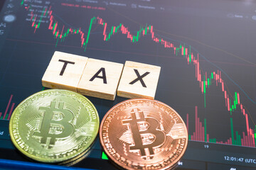 Cryptocurrencies with TAX word and stock chart candlestick on tablets background