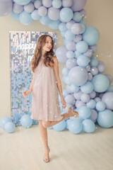 Fototapeta premium girl in a beautiful dress against the background of New Year's decorations from balls