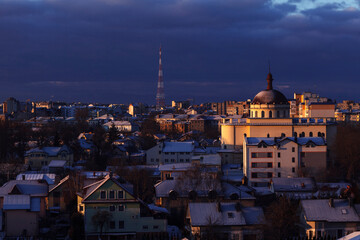 Fototapeta na wymiar Winter cityscape. Winter City Top View Sunrise. City panorama in winter with snow in house roofs. 