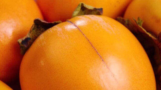 Fresh ripe persimmon fruit close-up. Macro. Slow rotation.