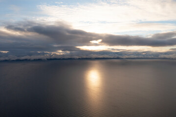 Obraz premium Aerial view clouds over the sea. View from drone. Aerial top view cloudscape. Texture of clouds. View from above. Sunrise or sunset over clouds. Aerial ocean background