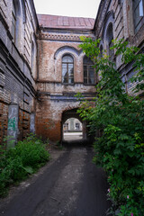 Fototapeta na wymiar Entrance to the courtyard of a dilapidated merchant building of the 19th century in the city of Kamen-na-Ob, Russia