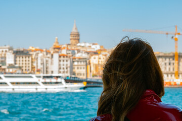 Woman looking to Istanbul. Young woman on the boat looking to Galata Tower