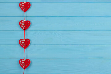 Decorative red hearts on blue wooden background with copy space for text. Valentine's Day celebration concept
