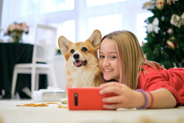 Friendship Concept. Teenage girl taking selfie with her dog at home. Dog lover with domestic animal