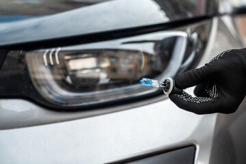 man replacing a h7 halogen burnt out lamp in auto headlight