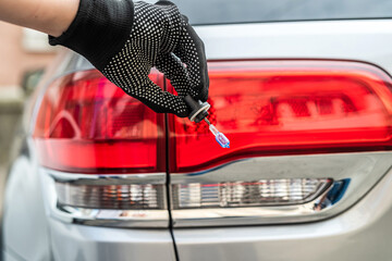 mechanic hand holding halogen light bulb near on car headlight