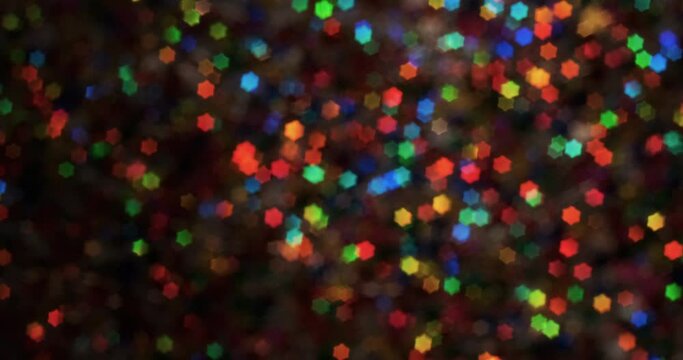 Rotating background of multi colored starry bokeh. Festive background. Abstract blurred