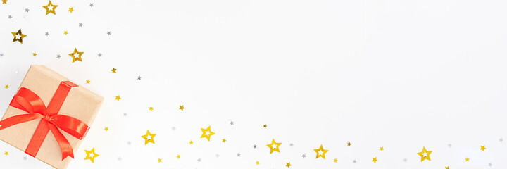Banner with gift boxes, red ribbon, silver and gold stars on a white background. New Year and Christmas card. Flat lay, top view, copy space.