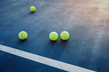 tennis balls on blue court.