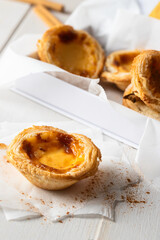 Portuguese egg custard tart pastry dusted with cinnamon. Pasteis de Belem on white background.