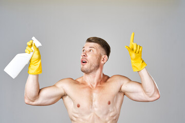 pumped up man posing with detergent in rubber gloves