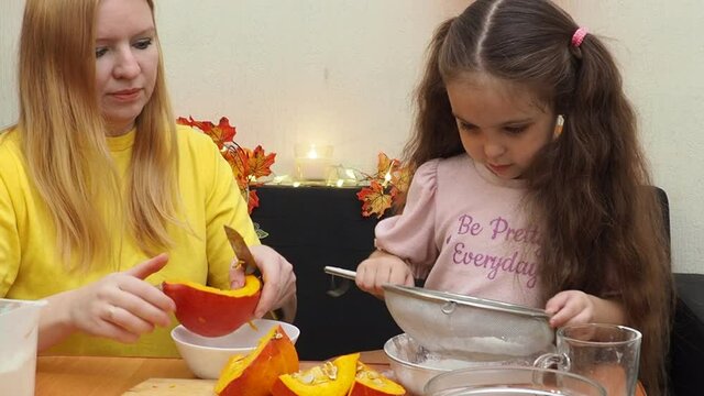 Mam And Daughter Are Making Dough pie For Thanksgiving Pie. put the dough in a mold for a thanksgiving pumpkin pie. Process of making Pumpkin pie for Thanksgiving Day. Seasonal traditional autumn fest