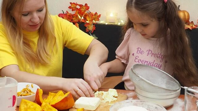 Mam And Daughter Are Making Dough pie For Thanksgiving Pie. put the dough in a mold for a thanksgiving pumpkin pie. Process of making Pumpkin pie for Thanksgiving Day. Seasonal traditional autumn fest