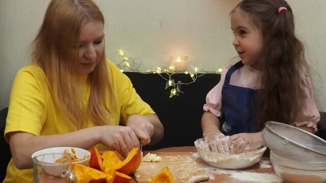 Mam And Daughter Are Making Dough pie For Thanksgiving Pie. put the dough in a mold for a thanksgiving pumpkin pie. Process of making Pumpkin pie for Thanksgiving Day. Seasonal traditional autumn fest