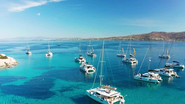 Yacht near the green island in Greece. Luxury vacation at sea.
