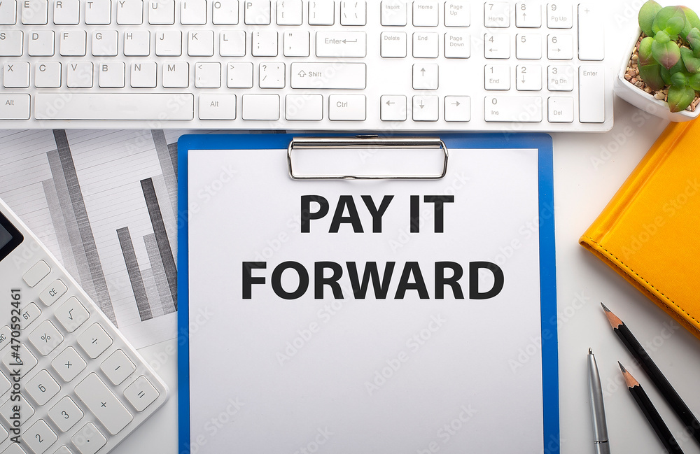 Poster pay it forward written on the paper with keyboard, chart, calculator and notebook
