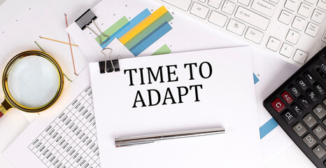 Business concept. Paper with text TIME TO ADAPT , near a calculator and charts.