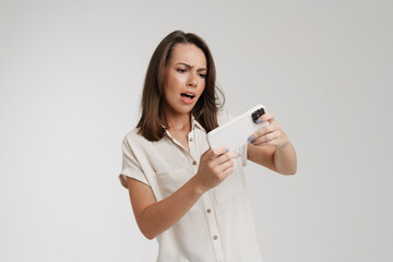 Young european woman playing video game on cellphone