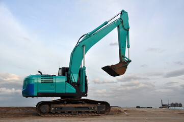 The green excavator vehicle after use and is parked by the port