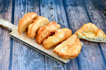 Traditional Bulgarian home made deep fried  patties  covered with sugar  оn rustic backgroud.Mekitsa or Mekica,  on wooden  rustic  background. Made of kneaded dough that is deep fried 