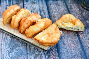 Traditional Bulgarian home made deep fried  patties  covered with sugar  оn rustic backgroud.Mekitsa or Mekica,  on wooden  rustic  background. Made of kneaded dough that is deep fried 